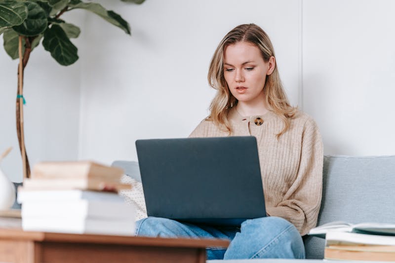 Vrouw studeert thuis met laptop en boeken
